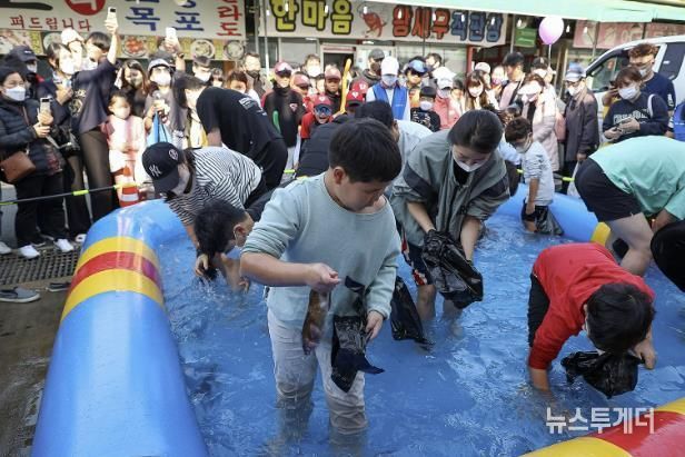 제10회 시흥월곶포구축제 중 맨손 고기잡이 체험에 참여 중인 시민들