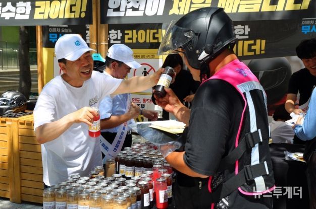 근로복지공단 박종길 이사장(왼쪽)이 지난 7월 서울 역삼역 인근에서 배달라이더들에게 시원한 음료를 나누어 주면서 고용·산재보험 거리 홍보를 진행했다.