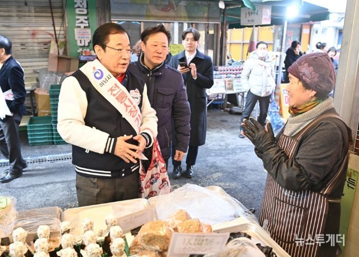 12일 오후 전통시장을 방문한 이현재 하남시장이 직접 장바구니를 들고 점포를 돌며 상인들에게 격려의 인사를 건네고 있다.